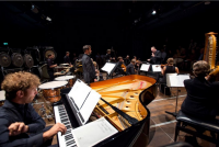 Es musizieren Mitglieder des reich mit Streichern und Bläsern besetzten ensemble risonanze erranti unter der Leitung von Peter Tilling.